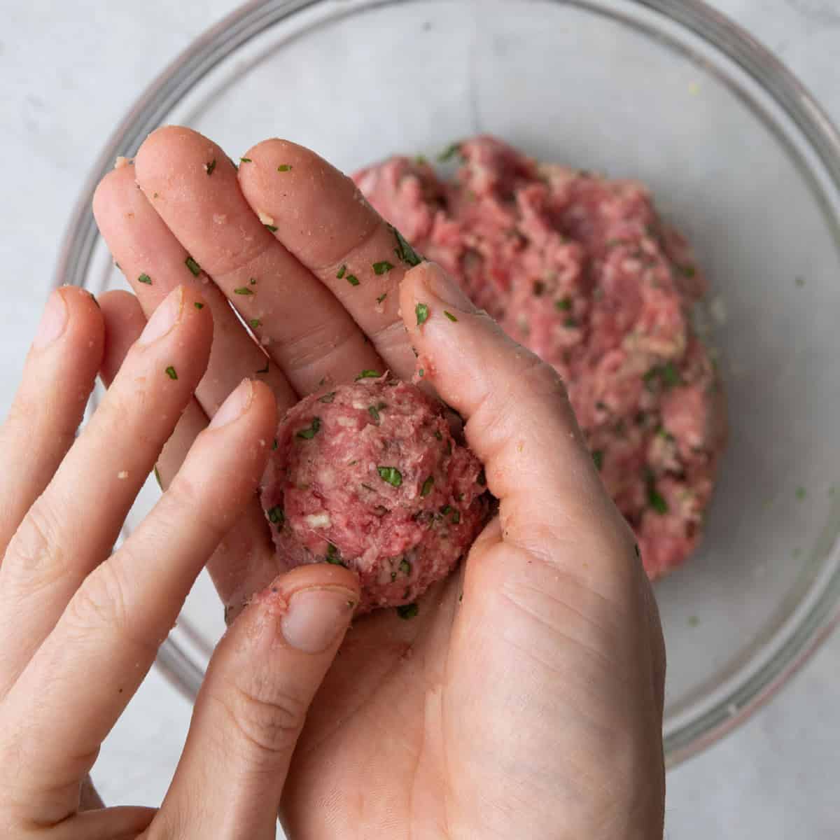Hand forming meatballs.