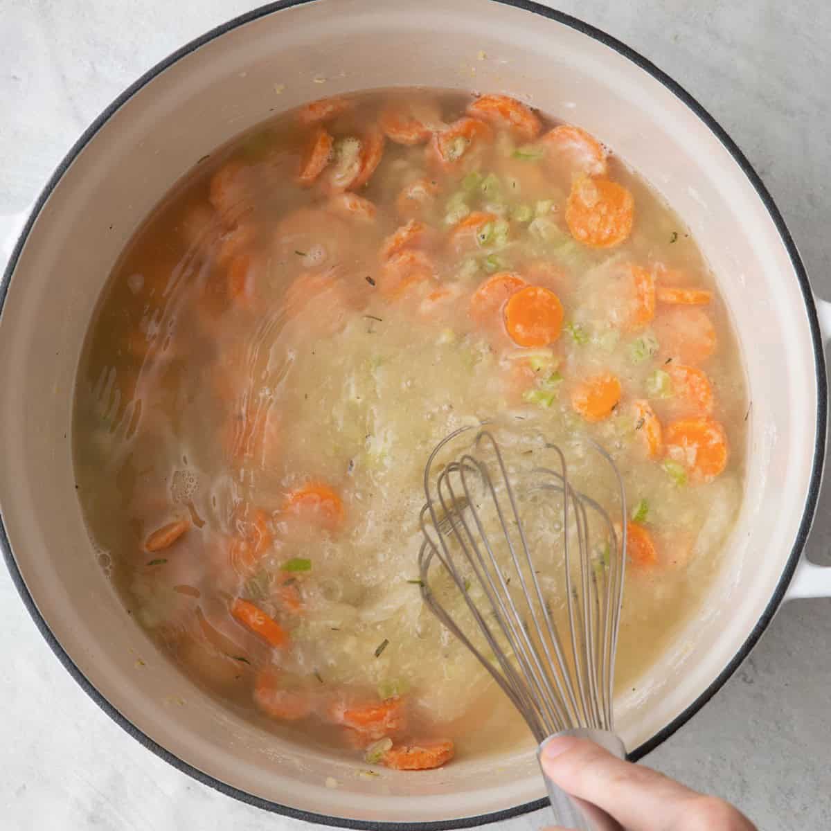 Whisking in chicken stock.