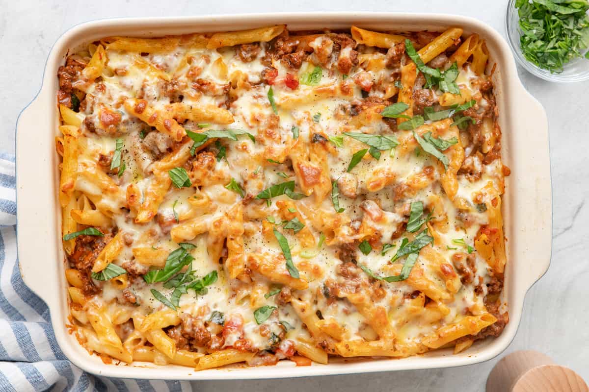 Beef casserole in baking dish garnished with fresh basil.