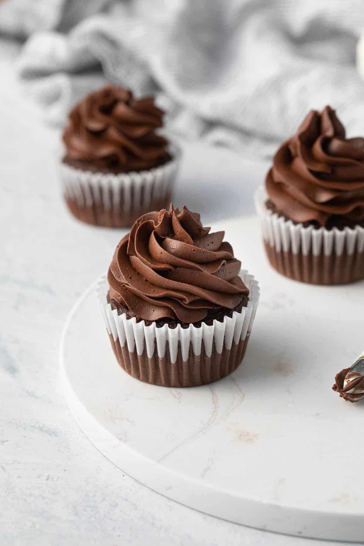 Whipped ganache piped on a chocolate cupcake.