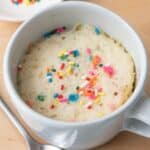 Vanilla mug cake with a spoon nearby.