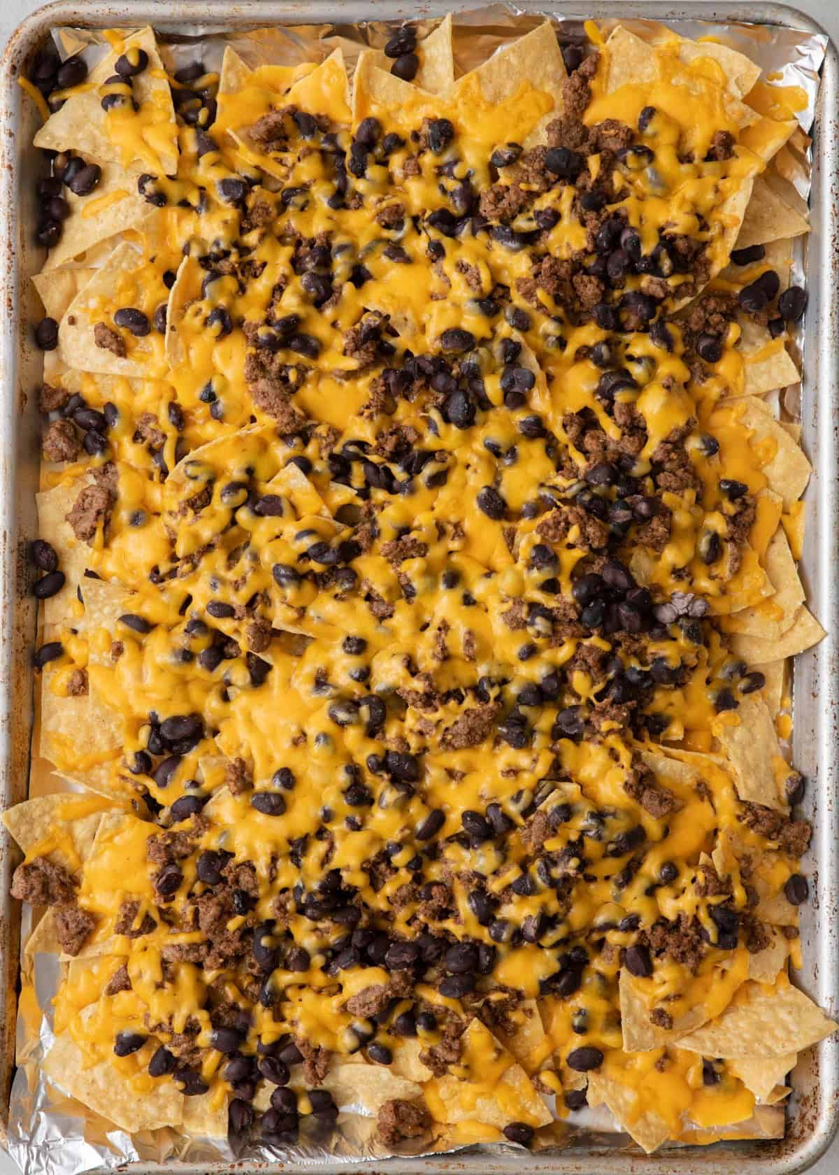 Nachos after baked showing melty cheese.