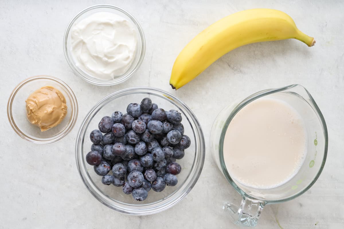 Ingredients to make the recipe: blueberries, bananas, hemp seeds, milk, almond butter