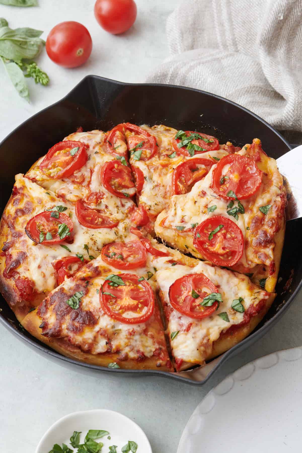 Cast Iron Pizza garnished with basil and sundried tomatoes
