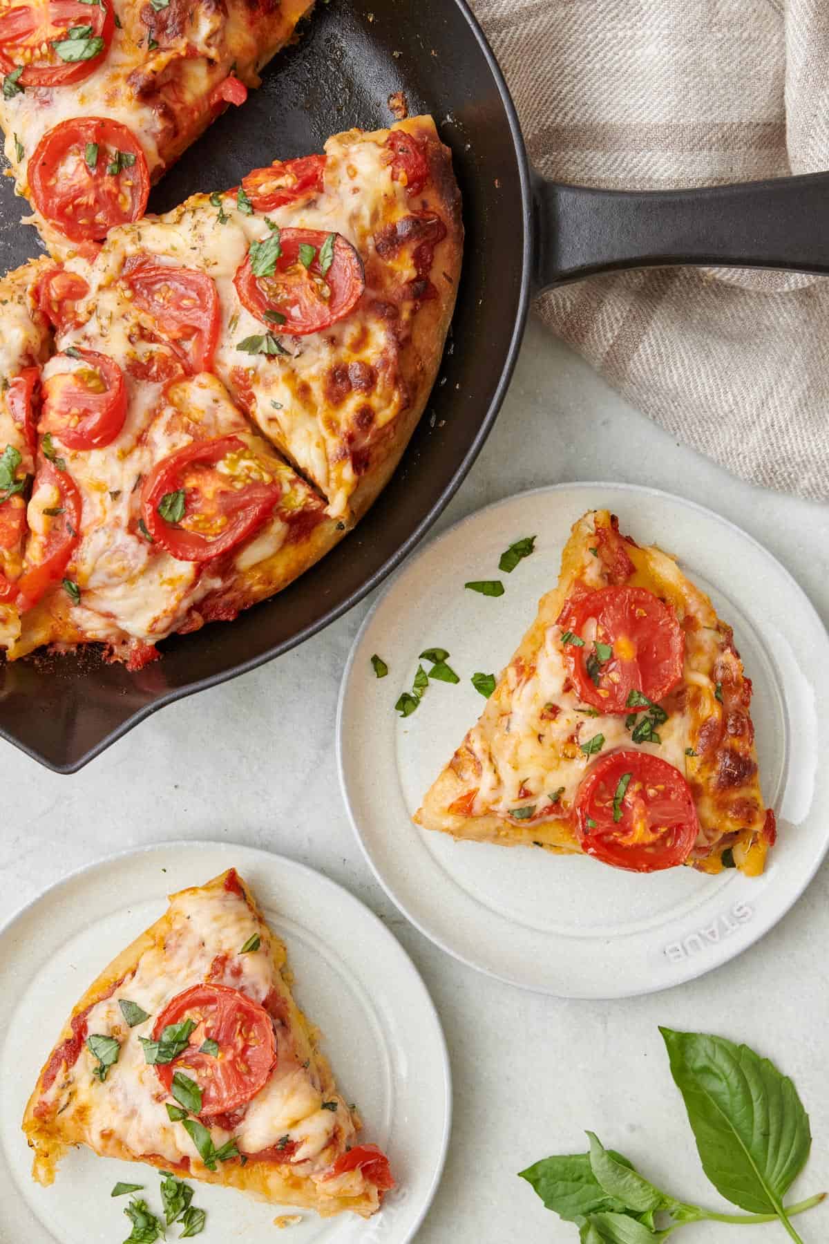 Slice of pizza served topped with fresh basil