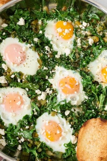 Green Shakshuka cooked in a large skillet.