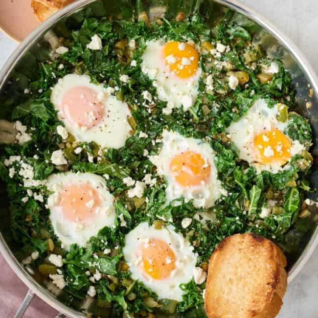Green Shakshuka cooked in a large skillet.