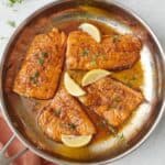Honey lemon salmon in a skillet.