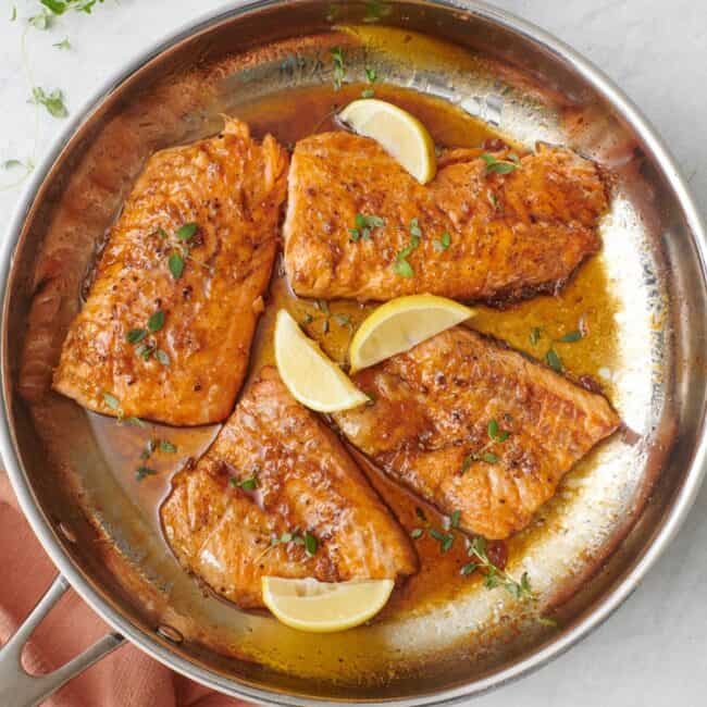 Honey lemon salmon in a skillet.