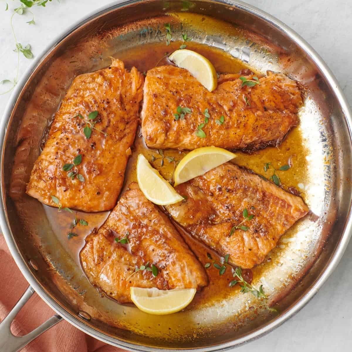 Honey lemon salmon in a skillet.
