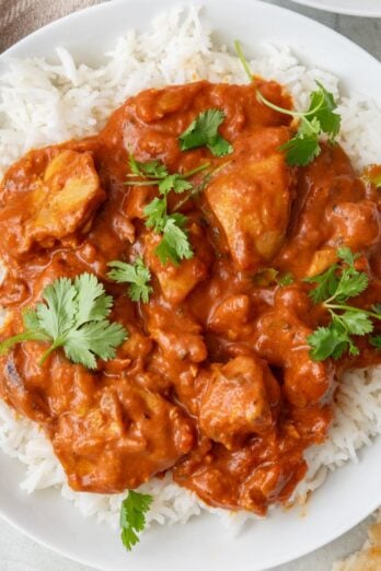 Instant pot butter chicken being lifted up with a ladle.