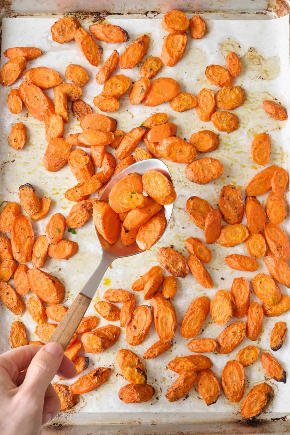 Large bowl of oven roasted carrots sprinkled with parsley