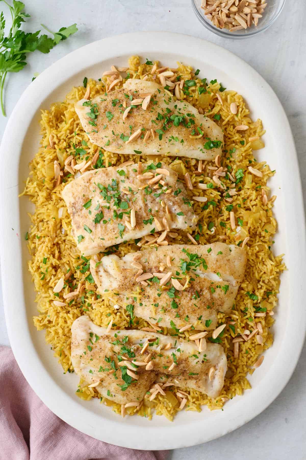 Large platter of Sayadieh, Lebanese rice with fish, garnished with toasted almonds.