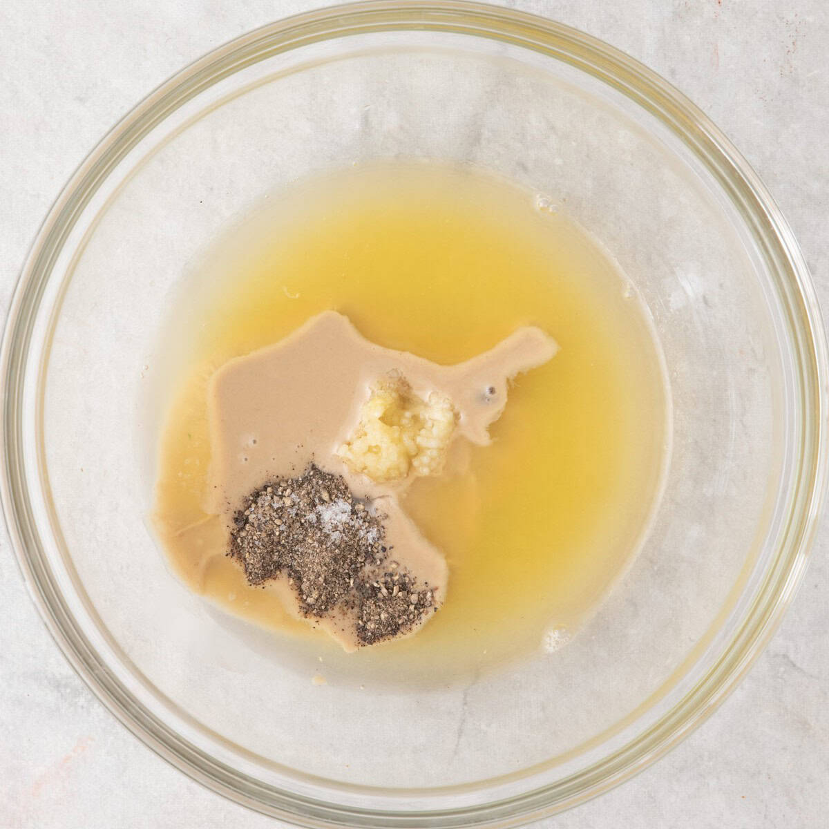 Dressing ingredients in bowl before whisked together.