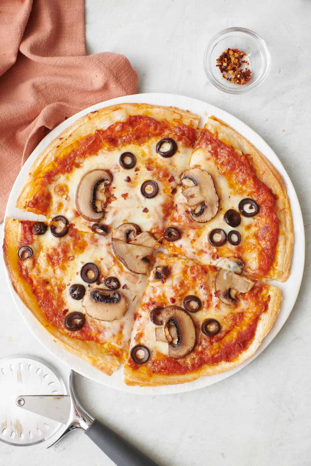 Pesto tortilla pizza sliced into four slices