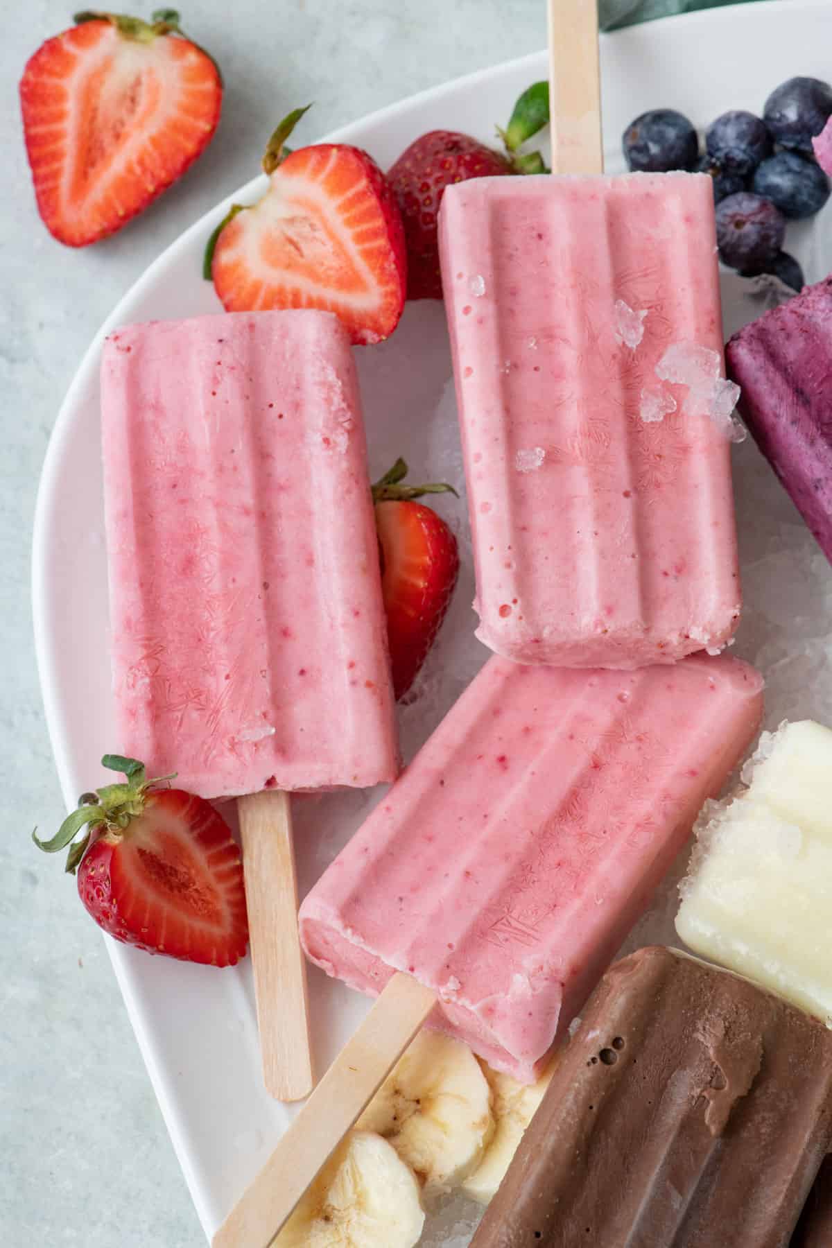Pink frozen yogurt popsicle with a bite taken out.
