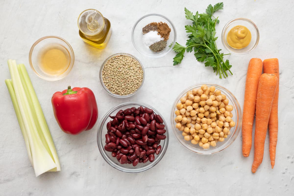 Ingredients for recipe: celery, red pepper, carrots, kidney beans, chickpeas, dry lentils, vinegar, oil, spices, parsley, and honey mustard.