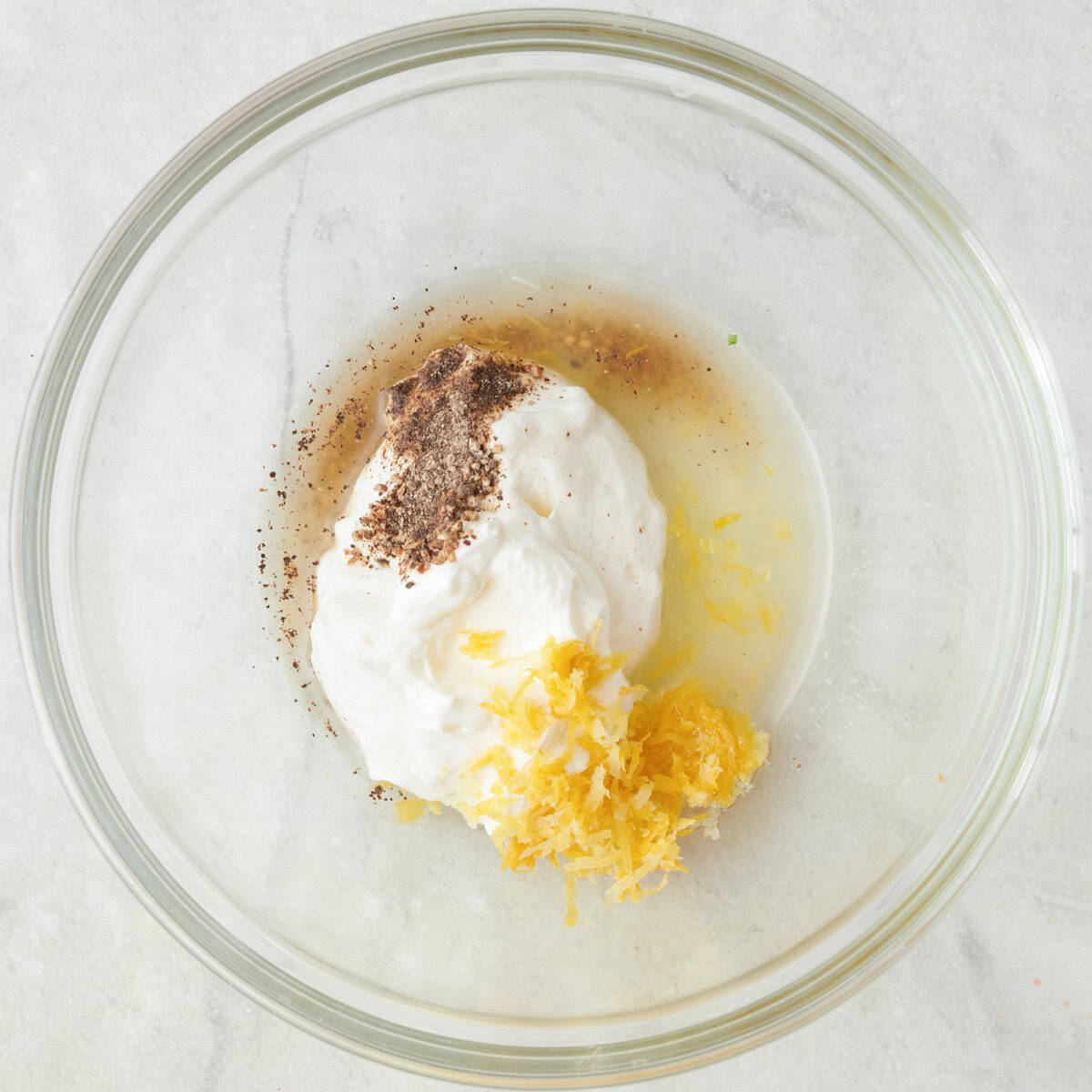 Yogurt, zest, juice, salt and pepper in a bowl before mixing.