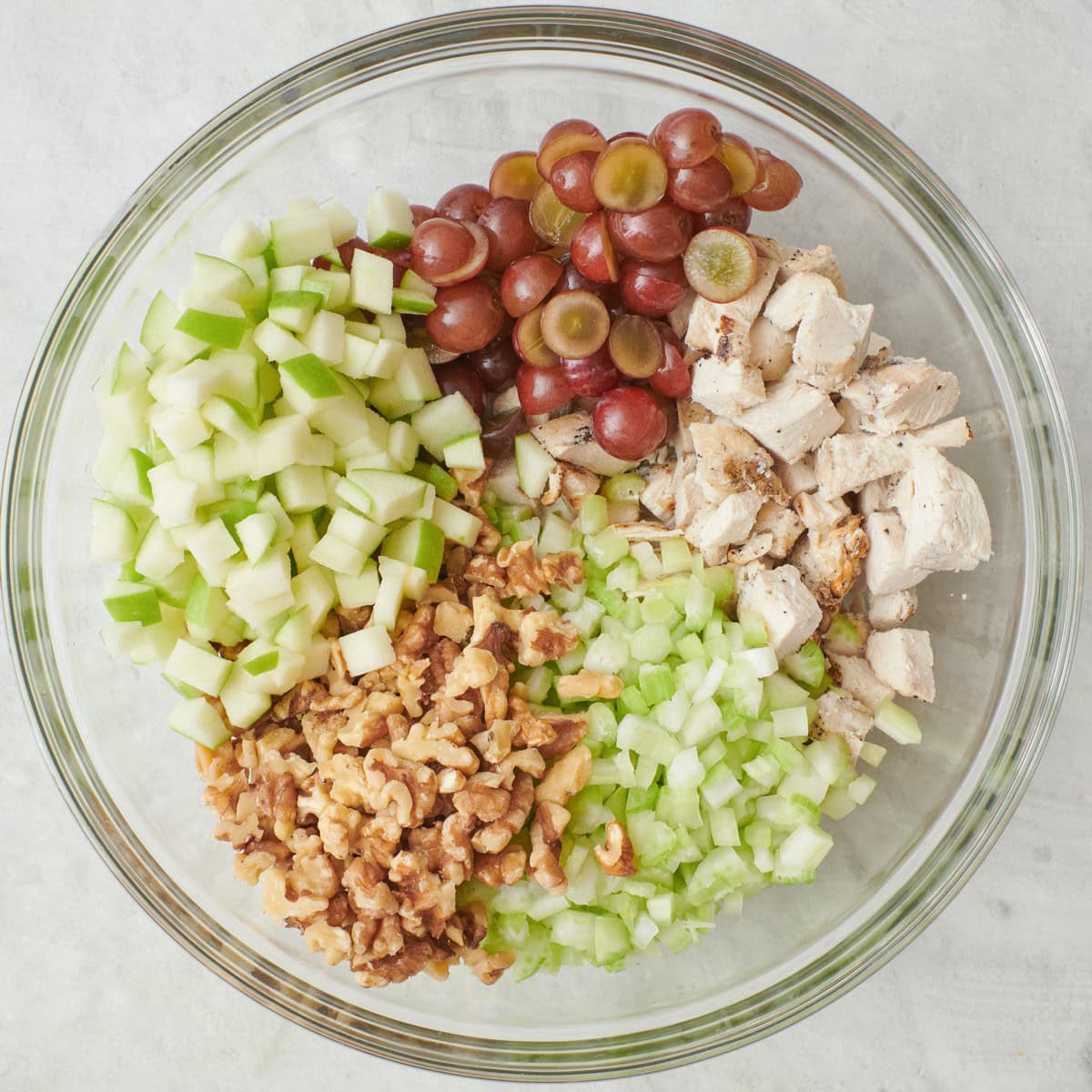 Chicken, celery, grapes, walnuts, and apple added on top of dressing in bowl before mixing.