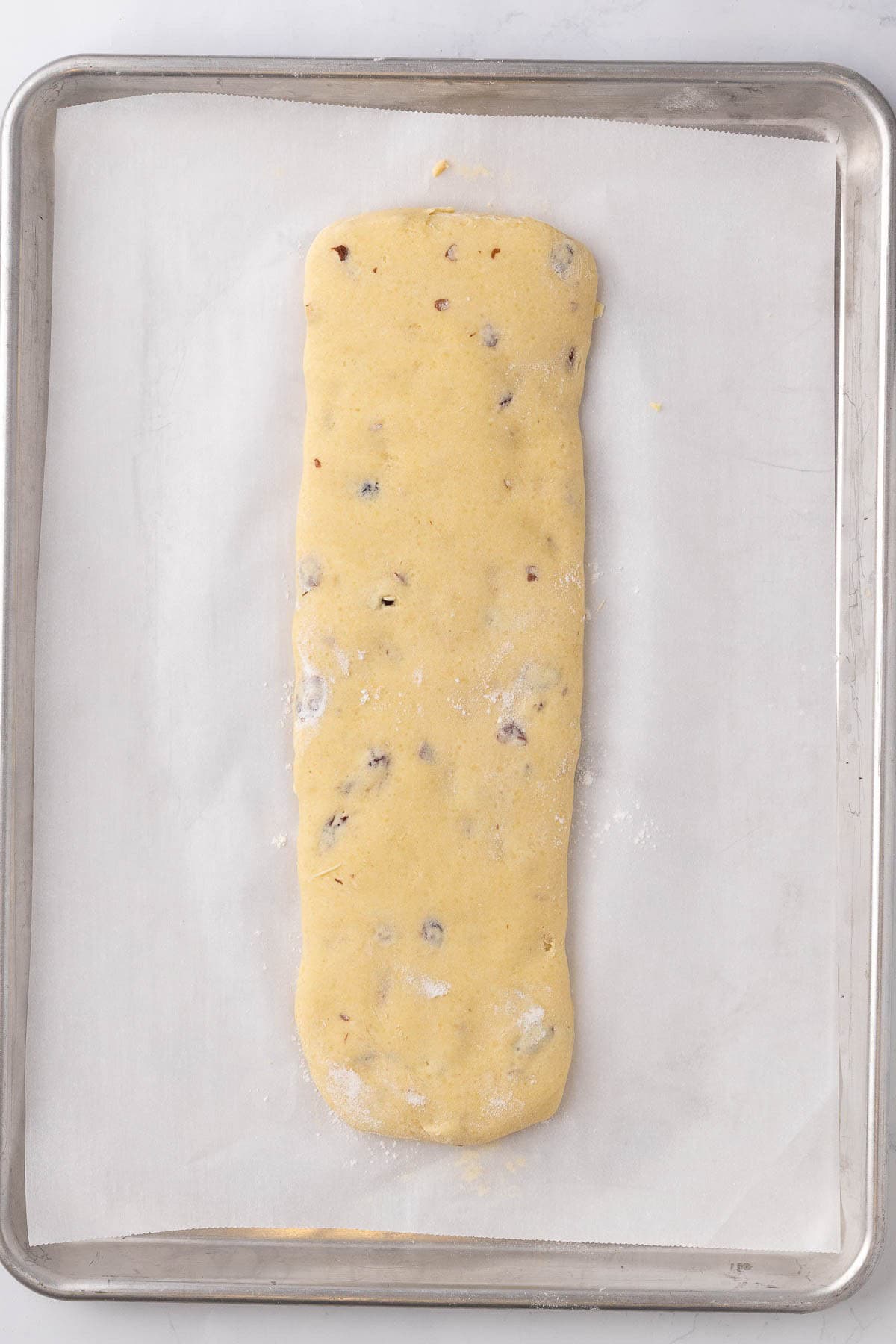Kneaded dough shaped on parchment paper.