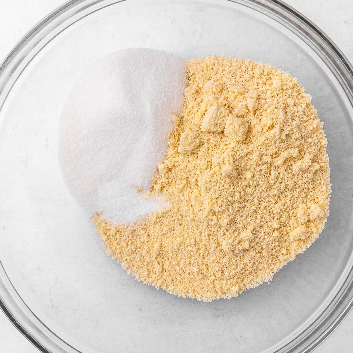 Almond flour, sugar, and salt in a bowl before combined.