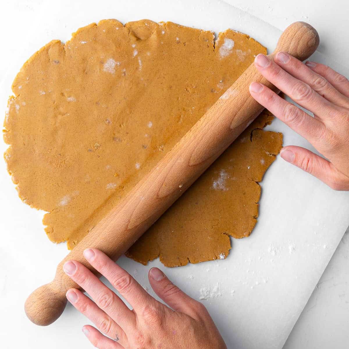 Rolling out the gingerbread cookie dough.