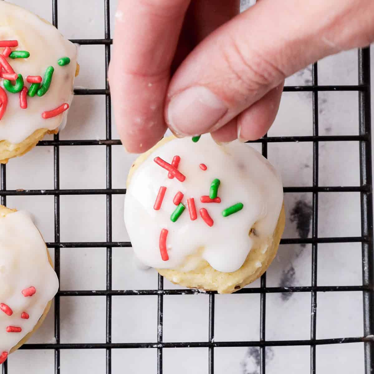 Adding sprinkles to wet icing on cookies.