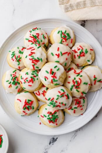 Decorated Italian Christmas cookies stacked on a round plate.