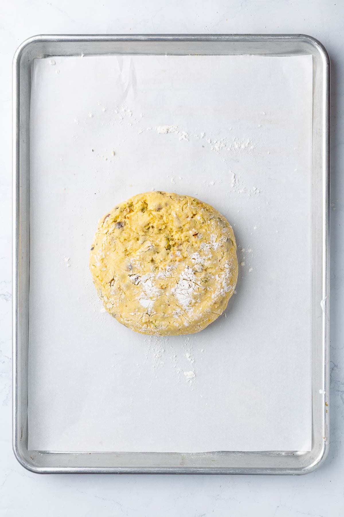 Kneaded dough transferred to parchment paper lined baking sheet before shaped.