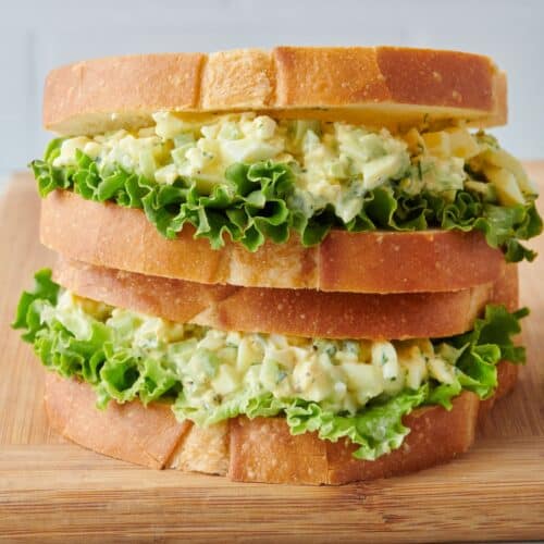 Two egg salad sandwiches stacked on top of each other.