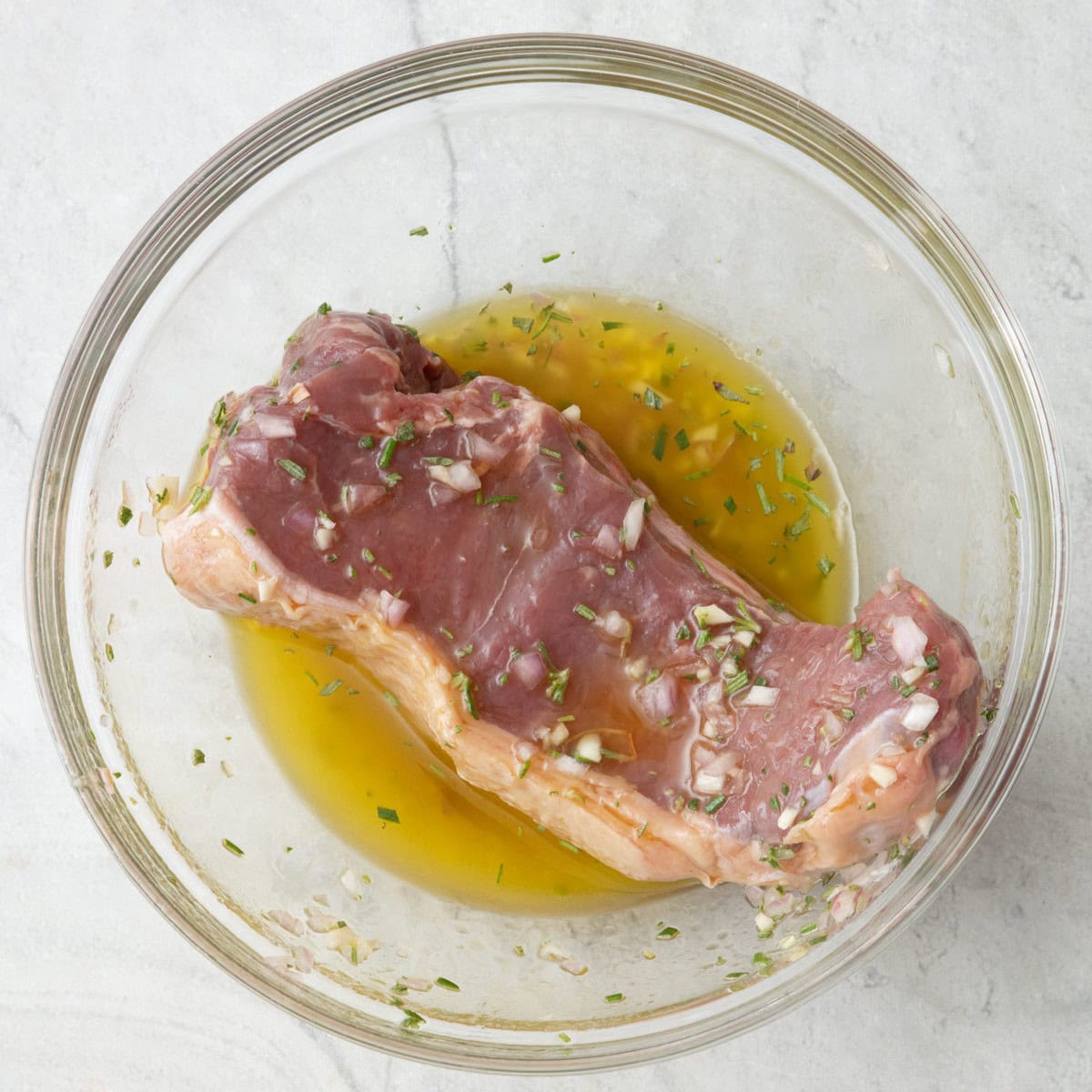 Steak added to the bowl of marinade.