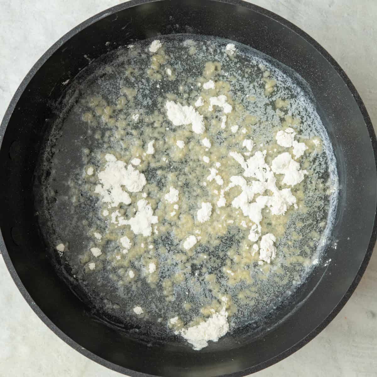 Melted butter in a pan with flour sprinkled over.