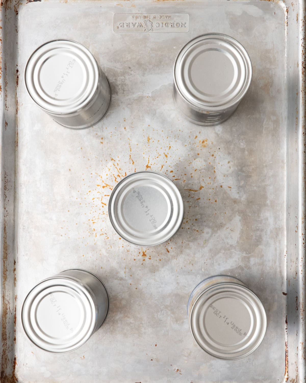 Another sheet pan added on top with a few unlabeled cans on top.