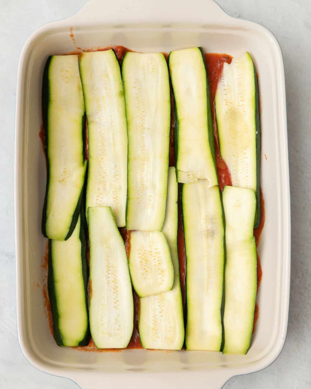 Layer of zucchini planks added on top of sauce.