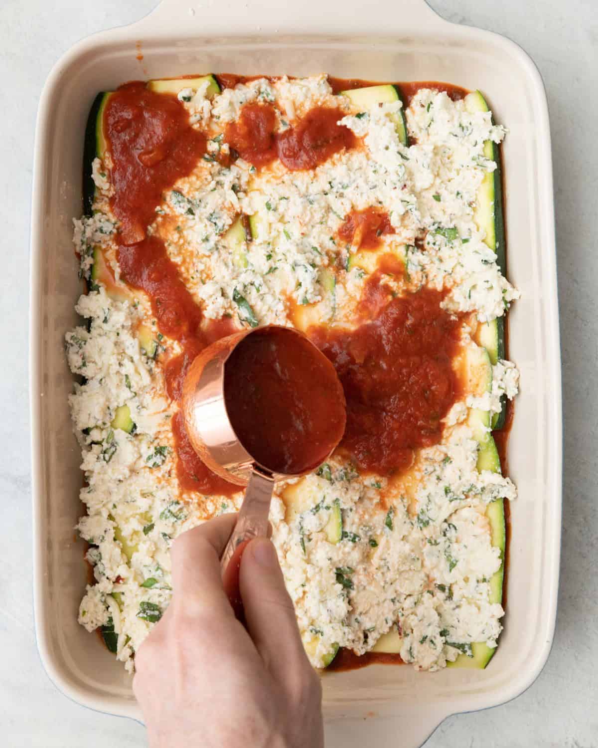 Ricotta spread evenly over planks and adding more marinara sauce.