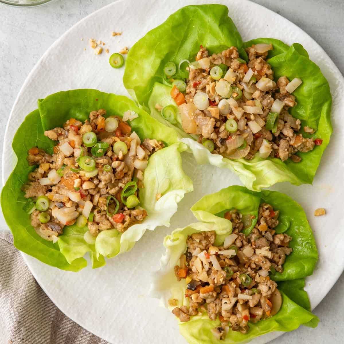 3 chicken lettuce cups on a plate.