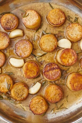 Fondant melting potatoes in skillet.