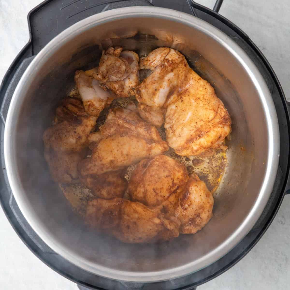 Seasoned chicken thighs in IP after flipping.