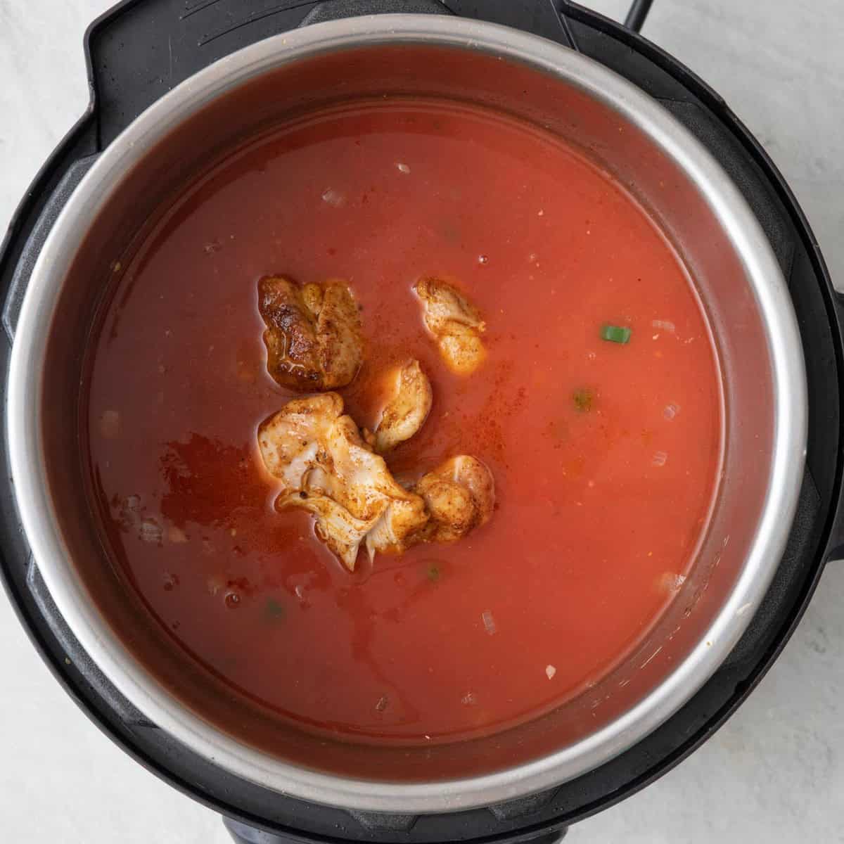 Tomatoes, broth, and partially cooked thighs.