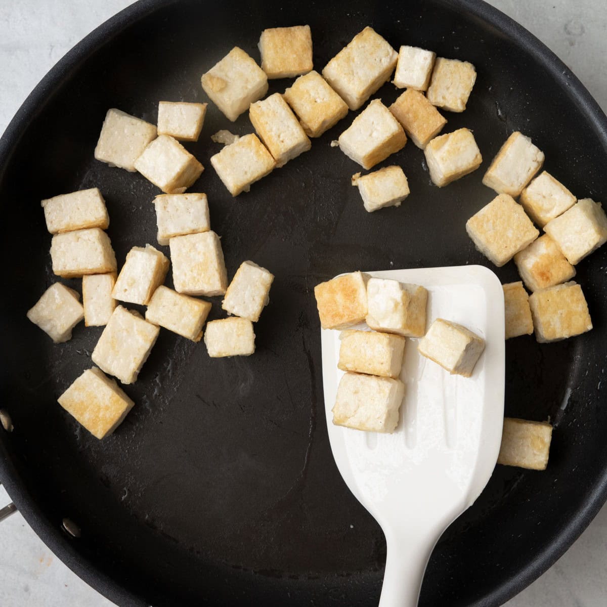Stir frying tofu cubes to show lightly golden brown color right before finished cooking.