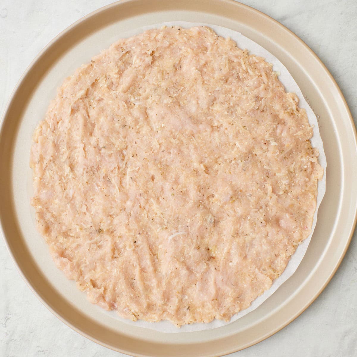 After pressing into a round pizza crust, before baking.
