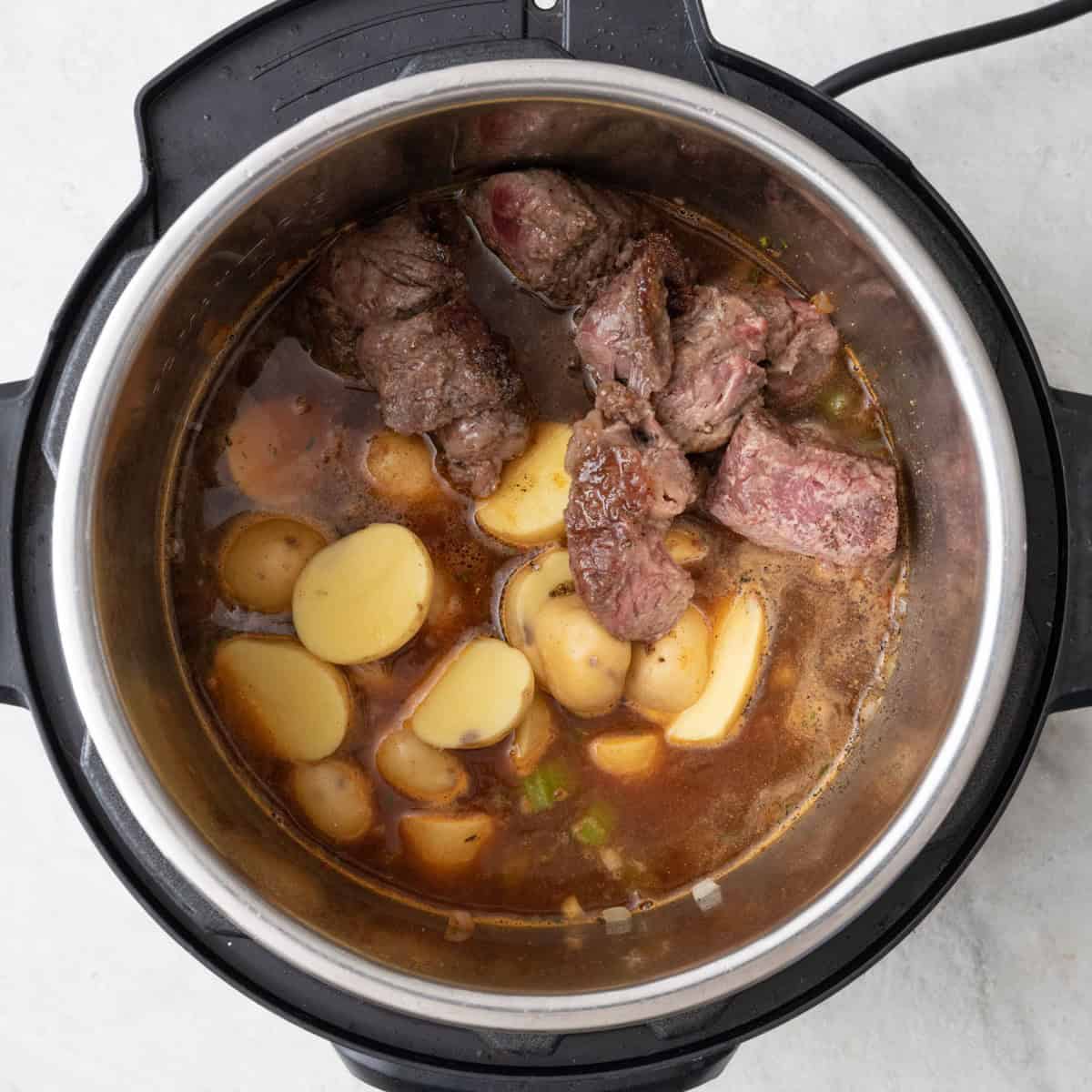 Beef broth, sun-dried tomatoes, potatoes, and reserved beef added.