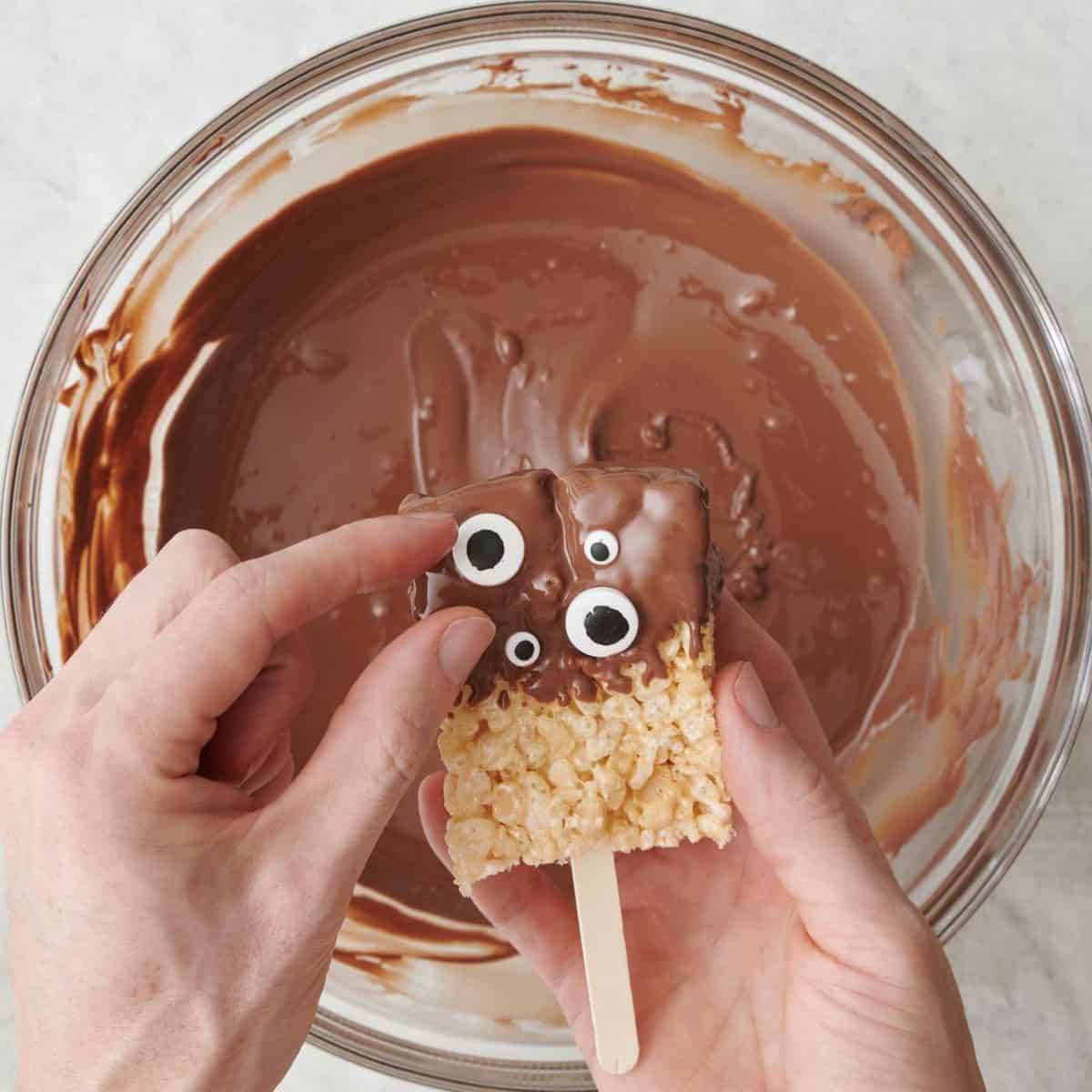 Adding eyes to one while chocolate is still wet.