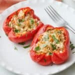 Two turkey stuffed pepper halves on a plate.