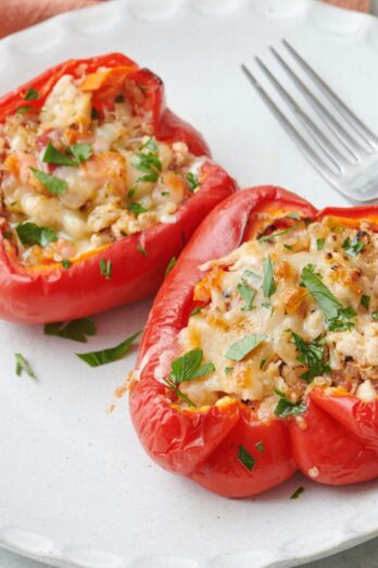 Two turkey stuffed pepper halves on a plate.