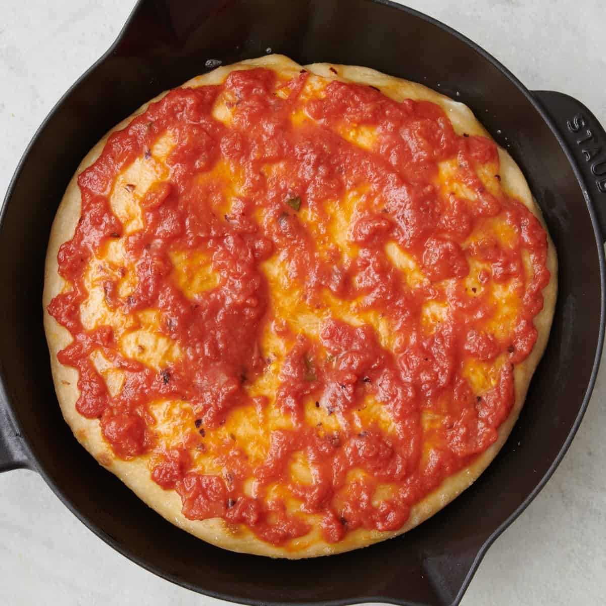 Marinara sauce on top of crust.