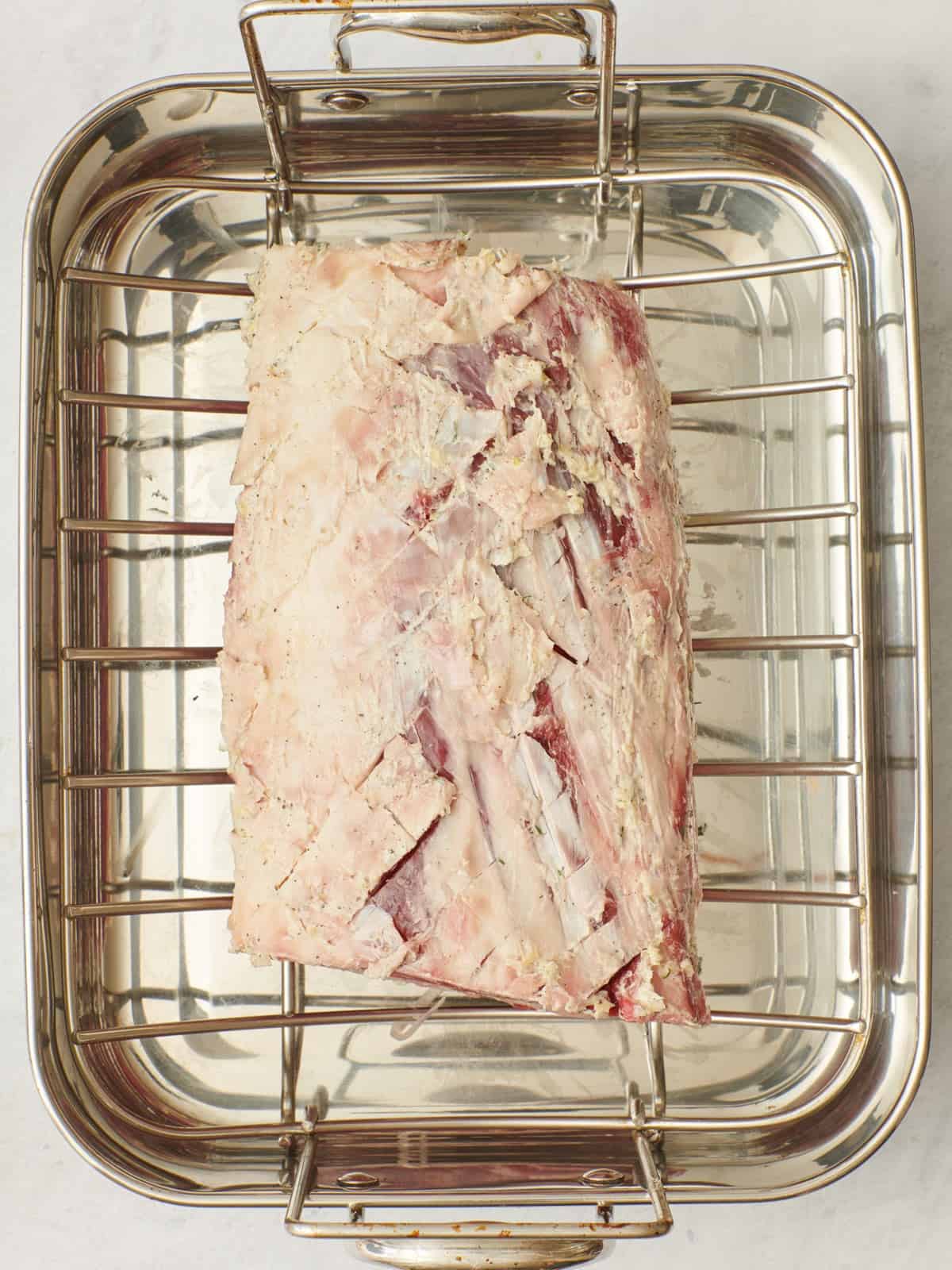Rib roast in a rimmed sheet pan with salt added.
