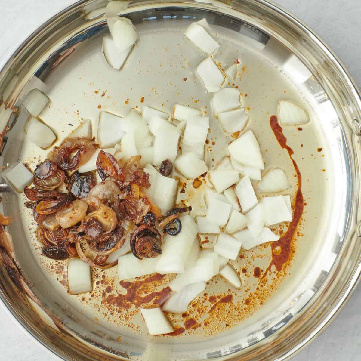 Fresh diced onions added to the roasting pan with drippings and shallots.