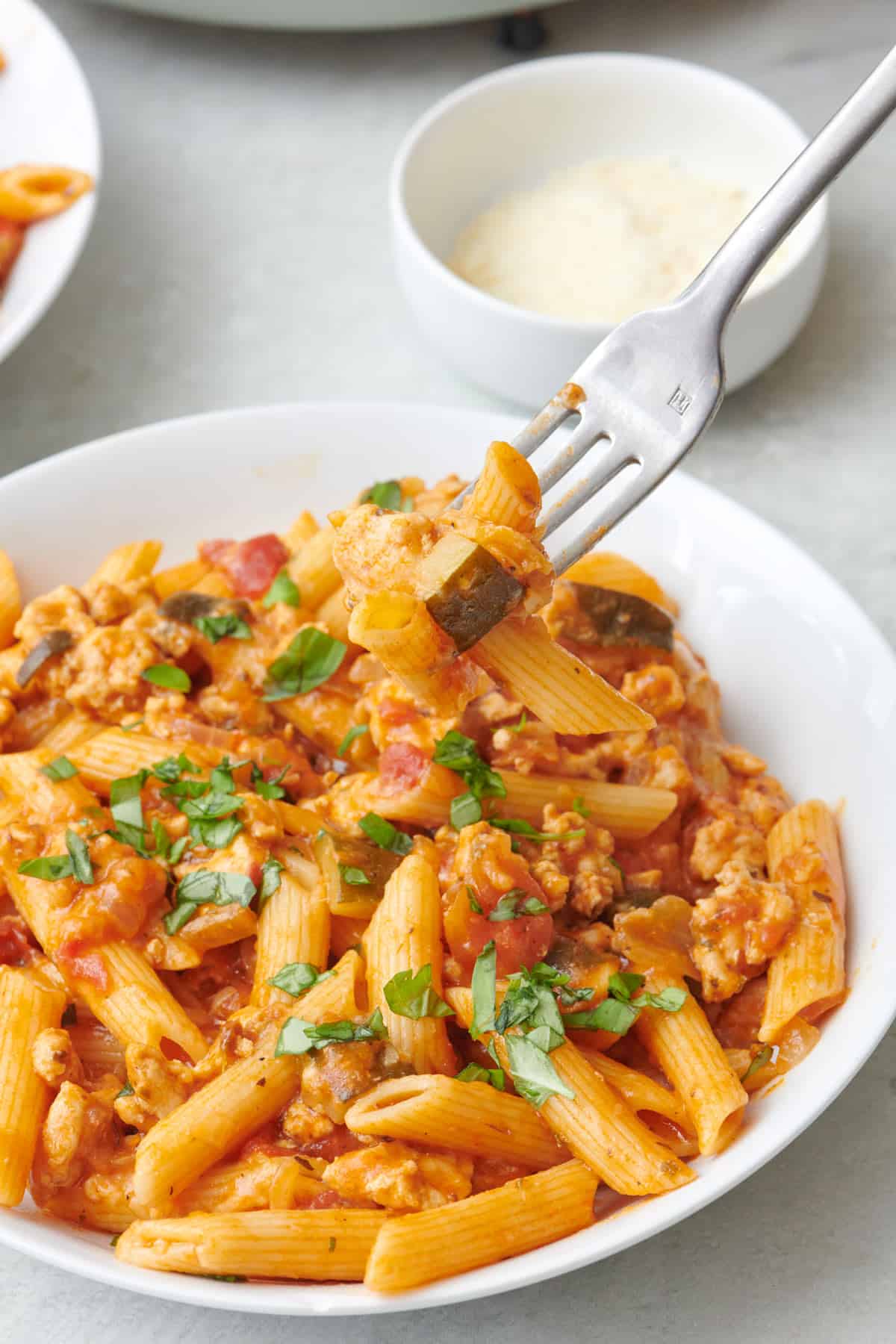 Fork lifting up a bite of ground turkey pasta.