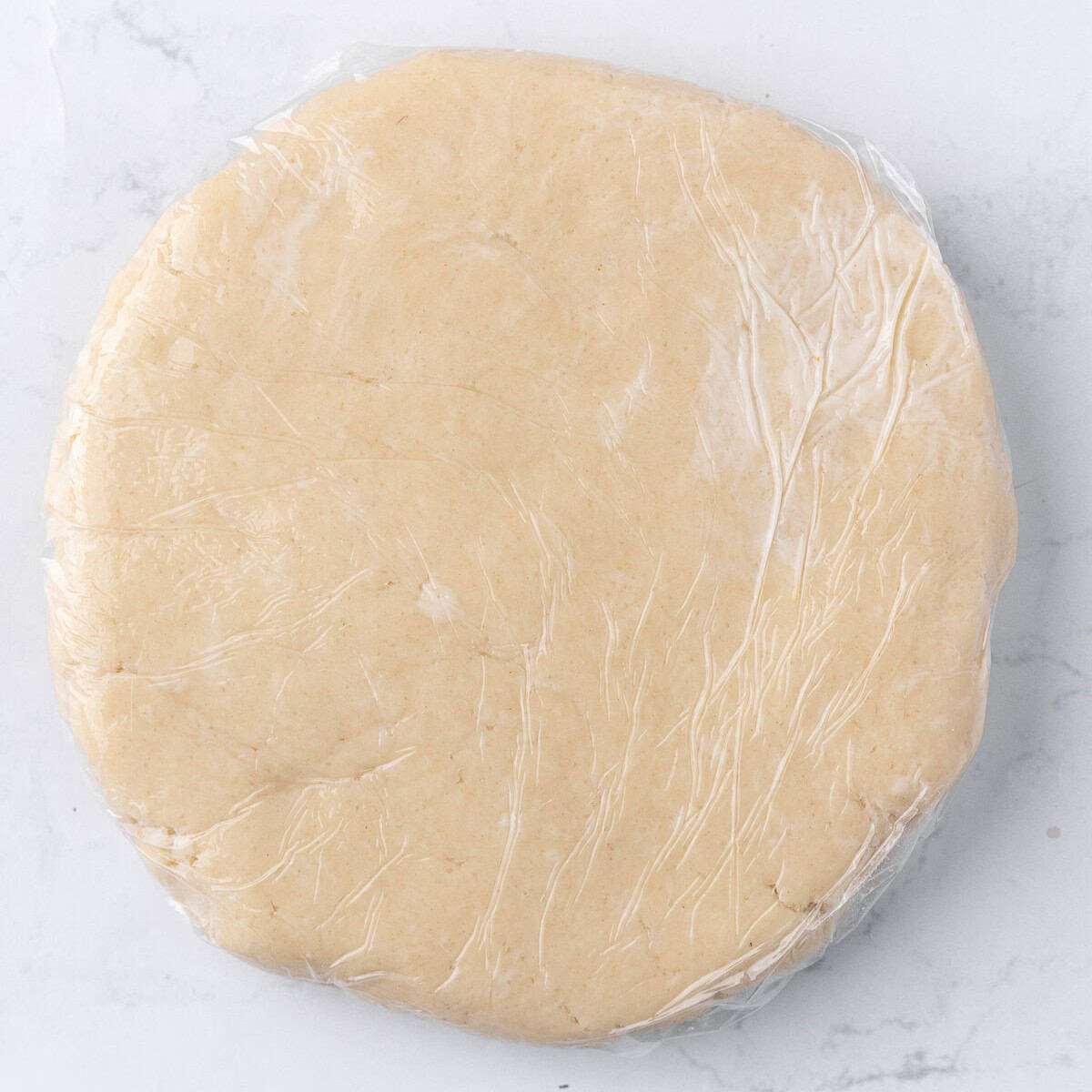 Transferred to a plastic wrap and formed into a disc.
